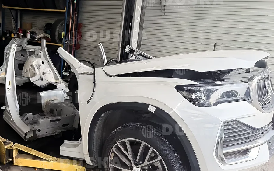 Автомобиль в процессе разбора в цеху: снятые панели и кузовной каркас рядом